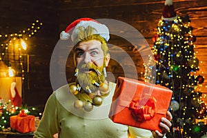 Santa winter portrait. Sexy Santa man posing on vintage wooden background. Bearded modern Santa Claus in knitted sweater