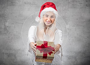 Santa woman giving christmas present box isolated on gray background. FOCUS ON FACE. Happy young girl holding gift