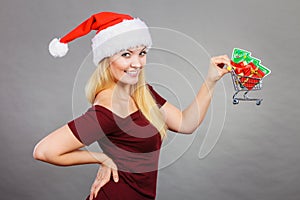 Santa woman holding shopping cart with christmas gifts