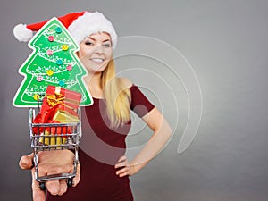 Santa woman holding shopping cart with christmas gifts