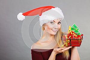 Santa woman holding shopping cart with christmas gifts