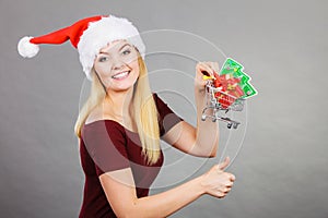 Santa woman holding shopping cart with christmas gifts