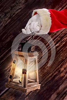 Santas hand holding a candle lantern