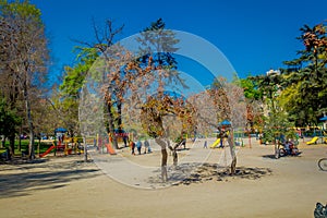 SANTIAGO, CHILE - SEPTEMBER 17, 2018: Unidentified people walking in the sandy playground at Forestal park located in