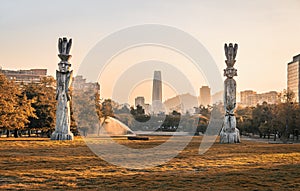 Santiago skyline at Araucano Park and chemamules traditional mapuche sculptures - Santiago, Chile photo