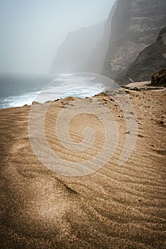 Santo Antao, Cape Verde - Cruzinha da Garca. Mountain moody coastline and Atlantic ocean waves. Sandy dune in foreground