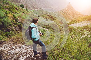 Santo Antao. Cape Verde. Photograph walking alone down the cobbled trekking trail towards green valley with huge rock in