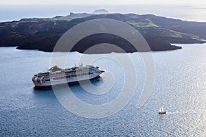 Large white passenger cruise ship in the old port of the Greek city of Fira. Sunset. Travel. Cruises