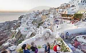 SANTORINI, GREECE - JULY 2014: Tourists enjoy classic greek city