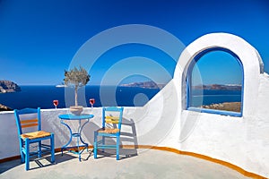 Santorini, Greece. Outdoor seating area with sea and horizon views. Two chairs and two glasses are hospitable. Santorini, Greece,