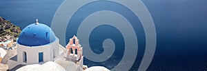 Santorini, Greece. Panorama of Greek Orthodox Church with blue dome in Oia village, aerial view