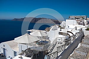 Santorini, Greece. Picturesq view of traditional cycladic Santorini houses on small street with flowers in foreground