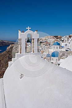 Santorini, Greece. Picturesq view of traditional cycladic Santorini houses on small street with flowers in foreground