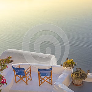 Santorini, Greece. Two chairs on the terrace overlooking the sea and sunset on the island of Santorini. Romantic time