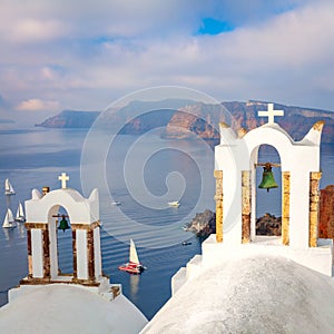 Santorini, Greece. White bell arch and blue sea view with boats. Conceptual composition of the famous architecture of Santorini