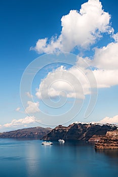 Santorini island, Greece. Blue sea and the blue sky with clouds. Cruise ships near the coast