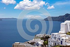 Santorini island, Greece. Oia caldera over Aegean sea, blue sky, calm sea