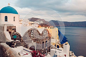 Santorini island Oia sunset landscape. Traditional white houses and church architecture with sea view. Travel to Greece