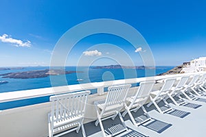 Santorini island. Romantic white chairs on white caldera with sea view. Luxury travel and vacation destination