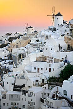 Santorini at Sundown. The famous town of Oia in the sunset. Traditional old windmills. Romantic holidays. Oia, Santorini, Greece