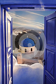 Santorini view with churches against blue door in Thira town, Greece