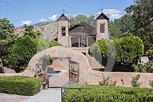 Santuario De Chimayo historic entrance way into adobe Roman Catholic Church landmark chapel in New Mexico is a pilgrimage site