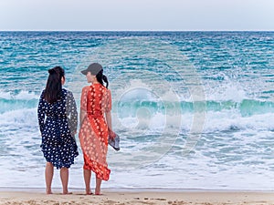 SANYA, HAINAN, CHINA - 4 MAR 2019 - Two young Asian Chinese women tourists at the beach with copy space