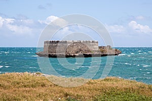 Sao Lourenco Blockhouse. San Lorenzo Island, fort nearby grassy shore and coastline of Mozambique island, Indian ocean coast.