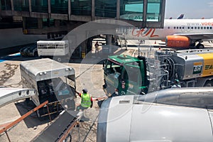 Petrobras Aviation tanker truck with fuel and workers loading luggage in the aircraft yard