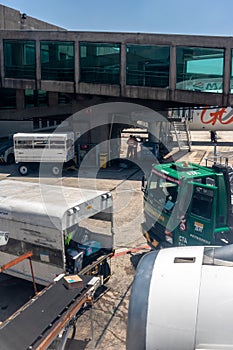 Petrobras Aviation tanker truck with fuel and workers loading luggage in the aircraft yard