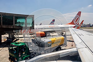 Etrobras Aviation tanker truck with fuel and workers loading luggage