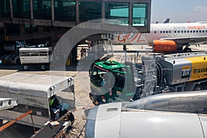 Petrobras Aviation tanker truck with fuel and workers loading luggage in the aircraft yard