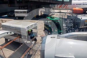 Petrobras Aviation tanker truck with fuel and workers loading luggage in the aircraft yard