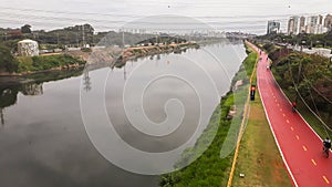 Sao Paulo, Brazil: Pinheiros river, cityscape, and bicycle path