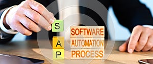 SAP concept. a man collects wooden blocks into the inscription Business process automation software and management software. photo