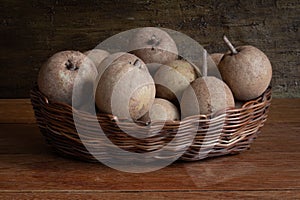 Sapotis  fruit  exposed  in basket in rustic wood background