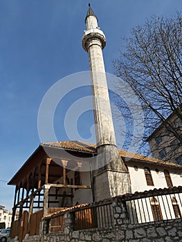 Sarajevo mosque with wooden roof and external terace combined with stone made minaret  with one balcony photo