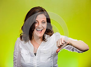 Sarcastic happy woman showing thumbs down hand gesture
