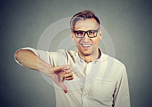 Sarcastic man showing thumbs down sign happy someone lost failed