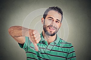Sarcastic young man showing thumbs down sign hand gesture