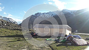 Sarchu Campting Tent with motorcycle in the middle of snow mountain range in northern of India