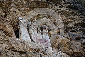 The sarcophagi of KarajÃ­a, Chachapoyas, Peru. These clay tombs have human forms and are set along the edge of a rock cliff