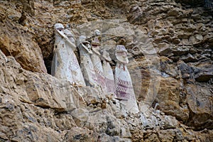 The sarcophagi of KarajÃ­a, Chachapoyas, Peru. These clay tombs have human forms and are set along the edge of a rock cliff