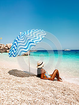Sardinia Orosei coast Italy, woman on vacation at the Island of Sardinia on a boat trip to all the white pebble beaches
