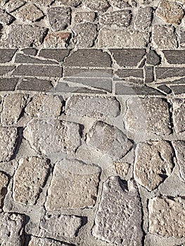 Sardinia. Traditional architecture. Urban road paved with rough ashlars and polished slabs of local volcanic stones. Detail photo