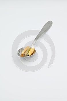 Sardinian gnocchetti pasta, also known as malloreddus or macarrones de punzu, on a spoon, isolated on a white background photo