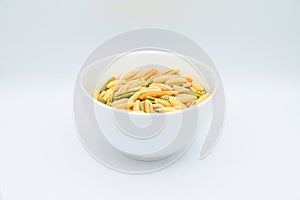 Sardinian gnocchetti pasta, also known as malloreddus or macarrones de punzu, in a white bowl, isolated on a white background photo