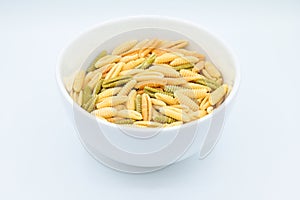 Sardinian gnocchetti pasta, also known as malloreddus or macarrones de punzu, in a white bowl, isolated on a white background photo