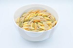 Sardinian gnocchetti pasta, also known as malloreddus or macarrones de punzu, in a white bowl, isolated on a white background photo