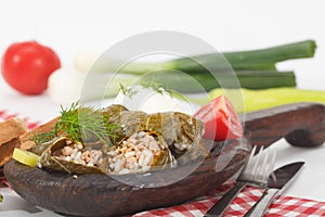 Sarma, stuffed grape leaves in wooden plate